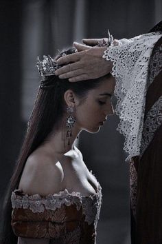 black and white photograph of a woman with long hair wearing a tiara, standing next to a man