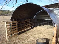 an outdoor area with fenced in animals and a barrel on the ground next to it