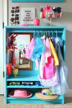 a blue bookcase with clothes hanging on it and the words dress up closet from an ikea billy