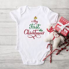 My First Christmas baby bodysuits is soft and comfortable. This baby bodysuit will be a great addition to any baby's wardrobe, and lap shoulders will make for easier changing. Red and green printing with a gold bell at top are perfect colors for your little one's first Christmas holiday. Celebrate your Christmas with this holiday baby bodysuit. Need a new mom or baby shower gift? This is just for you! This stunning baby bodysuit is available in short or long sleeve.  Perfect for Christmas gift giving! Printed on a direct to garment printer for great quality and durability. * Listing is for bodysuit only. Other items in pictures are for display purposes and are not included. * GARMENT FEATURES * 6.1 oz., ultra-soft 100% cotton interlock knit with piped leg seams * Piped leg seams * White is Holiday Outfit Christmas, Christmas Baby Clothes, My First Christmas Outfit, First Christmas Outfit, My 1st Christmas, First Christmas Baby, Christmas Bodysuit, Outfit Christmas, My First Christmas