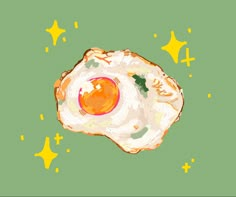 an egg is sitting on top of a green surface with yellow stars around it and the eggs have been fried