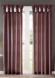 a living room with a large window and curtains in maroon color, the curtain is open