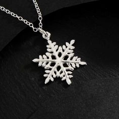 Sterling Silver Snowflake Charm Necklace NA1056 -SV-NECK This sterling silver snowflake charm necklace reminds us of the beauty of falling snow, a magical event binding heaven and earth. Tiny ice crystals fall from the sky as snowflakes form around a nucleus of earth-born dust. The geometric perfection of snowflakes has won it many admirers.  As if by some cosmic decree, every snowflake has six sides. Because the number six is associated with affection, the snowflake was used by Pagans as a symbol of love. Stock up on snowflake necklaces as the air chills and Christmas approaches. Perfect gift for winter birthdays, and Holiday parties. Comes on a simple 16, 18, 20, 22 inch cable chain with spring ring clasp.  Measurement (mm): Length: 18 Width : 16  Height: 1 - Snowflake Snow Necklace, Necklace Snowflake, Snowflake Jewelry, Crystal Falls, Number Six, Falling Snow, Snowflake Necklace, Stained Glass Jewelry, Ice Crystals