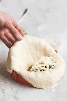 a person is kneading an uncooked pizza dough