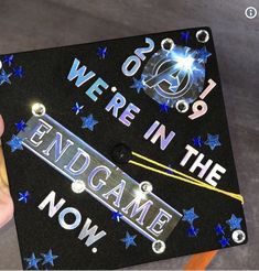 someone holding up a graduation cap that says we're in the endgame now