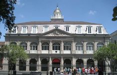 an old building with many people walking around it