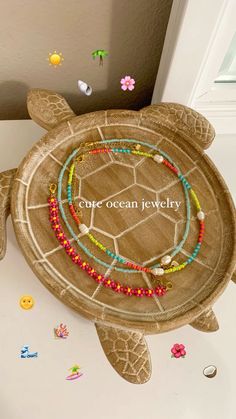 a turtle shaped tray with beaded bracelets on it's back and the words cute ocean jewelry written in large letters