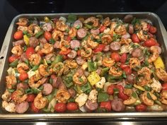 a pan filled with shrimp and vegetables on top of a stove