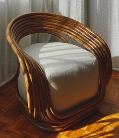 a wicker chair sitting on top of a hard wood floor next to a window