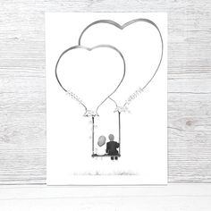 two heart shaped balloons are attached to the back of a card