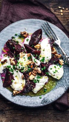 beet salad with goat cheese and walnuts on a plate next to a fork