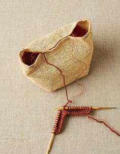 two crocheted baskets sitting next to each other on top of a cloth covered floor