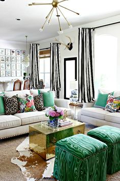 a living room filled with lots of furniture and colorful pillows on top of it's couches