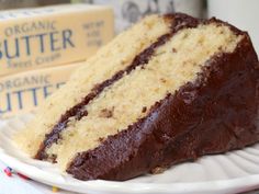 a slice of cake sitting on top of a white plate next to two boxes of butter