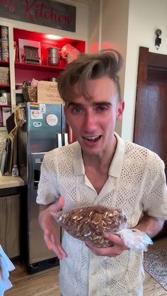 a young man holding a bag of food in his hand and smiling at the camera