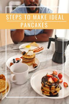 a man sitting at a table with pancakes on it