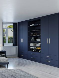 a bedroom with dark blue cabinets and white carpeted flooring in front of a large window