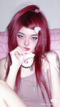 a young woman with red hair and piercings on her ears is sitting in bed