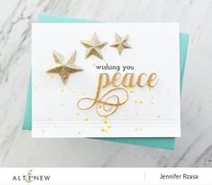 a card with three gold stars on it and the words wishing you peace written in cursive writing