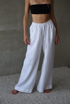 Upgrade your summer wardrobe with our modern, full-length linen pants. Made from 100% high-quality European linen, these breathable, wide-leg pants are perfect for staying cool and comfortable in warm weather. Designed by a talented designer and sewn in a small studio in Lithuania, these pants feature convenient pockets and a comfortable elastic waistband. They are ideal for casual outings, chic summer events, or strolls on the beach. Pair them with your favorite sandals or sneakers for an effor Solid Color Summer Wide Leg Full Length Pants, Summer Solid Color Wide Leg Pants, Summer Full Length Solid Wide Leg Pants, Summer Solid Color Full Length Wide Leg Pants, Solid Color Summer Wide Leg Pants, Baggy Wide Leg Beach Trousers, Baggy Wide Leg Pants For Beach, Baggy Wide Leg Vacation Pants, White Baggy Pants For Vacation