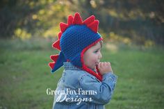 a small child wearing a crocheted hat with spikes on it's head