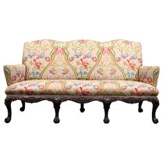 an ornately upholstered couch with floral fabric on it's back and arms