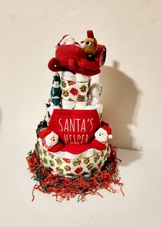 a three tiered christmas cake with santa's help written on it