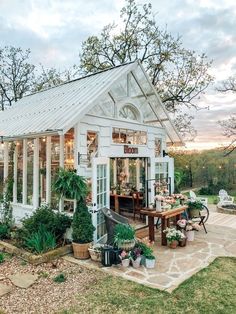 a small white house sitting on top of a lush green field