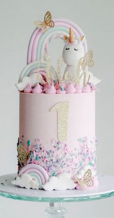 a birthday cake decorated with unicorns and stars