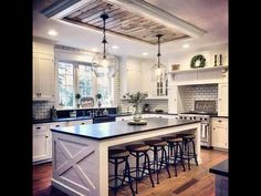 a large kitchen with an island in the middle and lots of stools around it