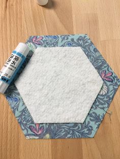 a hexagonal piece of fabric next to some glue