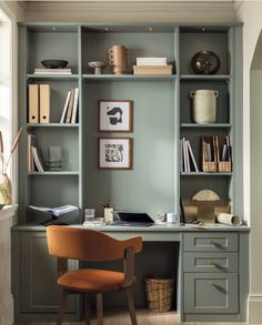 a chair sitting in front of a desk with bookshelves on top of it