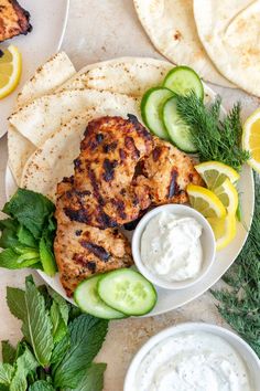 grilled chicken with cucumber, lemon and dill garnish on a plate