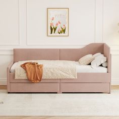 a pink daybed in a white room with flowers on the wall and carpeted floor