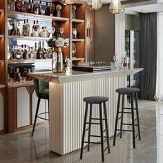 a bar with three stools in front of it