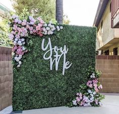 a sign that says you are surrounded by flowers and greenery on the side of a building