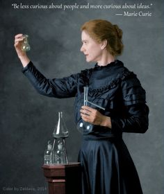 a black and white photo of a woman holding an object in one hand while wearing a dress