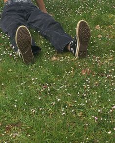 a person laying in the grass with their feet up