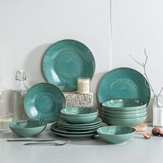 a table topped with lots of green plates and bowls on top of eachother