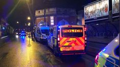 police cars and ambulances are parked on the side of the road at night time