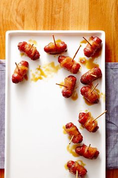 bacon wrapped in toothpicks on a white plate