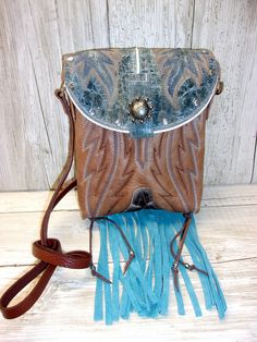 Crafted with a blend of rugged charm and western allure, these one-of-a-kind Small Leather Crossbody Purses are the epitome of cowgirl chic. Handcrafted from authentic cowboy boots, each purse exudes a sense of unique style that is perfect for those who embrace country fashion. The fringe detailing adds a touch of flair reminiscent of rodeo culture, making it a must-have accessory for any modern cowgirl. Whether you're hitting the town or attending a western-themed event, these purses effortlessly blend into your wardrobe, elevating your outfit with a dash of western chic. Embrace your inner cowgirl and make a bold statement with these stylish and versatile Crossbody Purses that are bound to turn heads wherever you go.  Small Cowboy Boot Purse with Fringe Handmade from 1-1/2 Boots Hand-cut Western Bags With Concho Detail, Western Style Bags With Concho, Hand Tooled Western Bags, Western Style Crossbody Bags For Western-themed Events, Purse With Fringe, Boot Purse, Cowboy Boot Purse, Hipster Purse, Custom Cowboy Boots