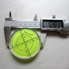 a caliper with a yellow circle on it and a measuring tool next to it