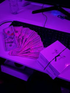 a bunch of money sitting on top of a desk next to a keyboard and mouse