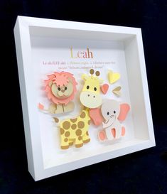 a white frame with three wooden animals in it