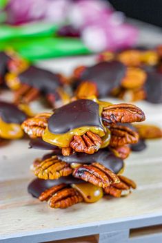 some pecans are stacked on top of each other with chocolate drizzled over them