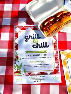 two hot dogs in buns on a red and white checkered picnic tablecloth