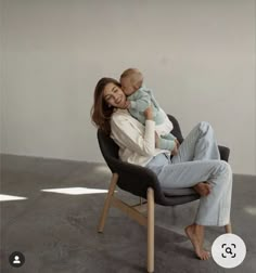 a woman sitting in a chair holding a baby