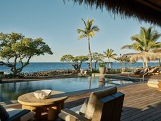 an outdoor swimming pool with lounge chairs and palm trees