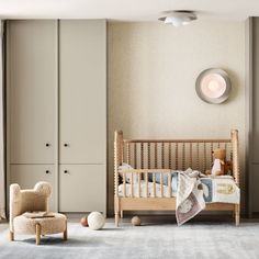 a baby's room with a crib, chair and stuffed animals